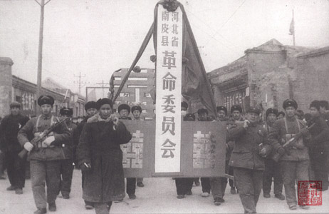 县革命委员会的成员肩扛“河北省南皮县革命委员会”的匾牌沿县城街道游行